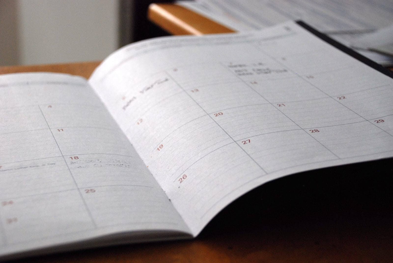 Open planner showing a monthly calendar layout on a desk, ideal for scheduling and time management.