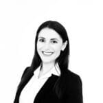 Professional woman in business attire, smiling confidently, isolated on white background. Ideal for corporate profile or LinkedIn.