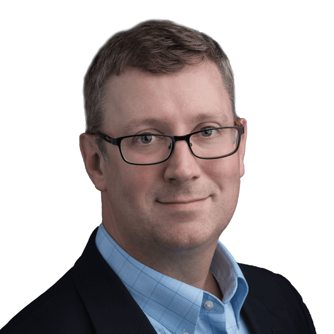 Professional portrait of a man in glasses, wearing a blue shirt and blazer, on a plain background.