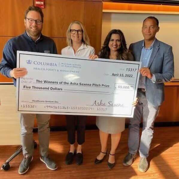 Columbia Venture Day winners holding Asha Saxena Pitch Prize check, awarded $5,000 for healthcare innovation.