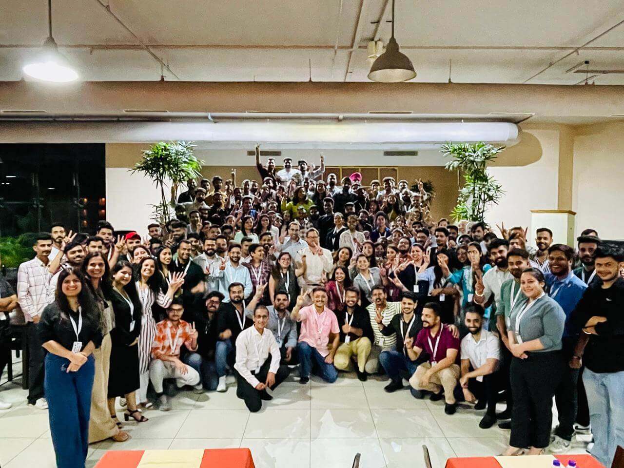 Large group of diverse professionals at corporate event, smiling and posing indoors, teamwork and networking concept.