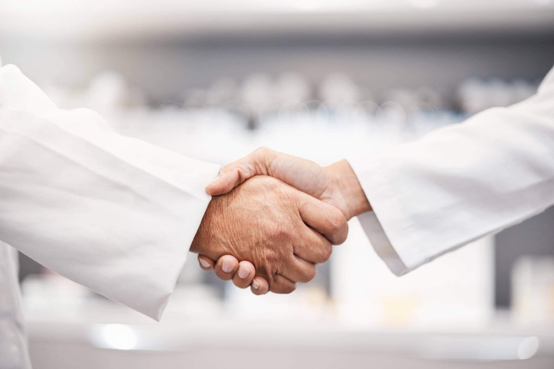 Close-up of doctors shaking hands, symbolizing collaboration and teamwork in healthcare.