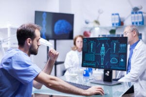 Young scientist analyzing male body on computer in lab, medical research, healthcare technology, science innovation.